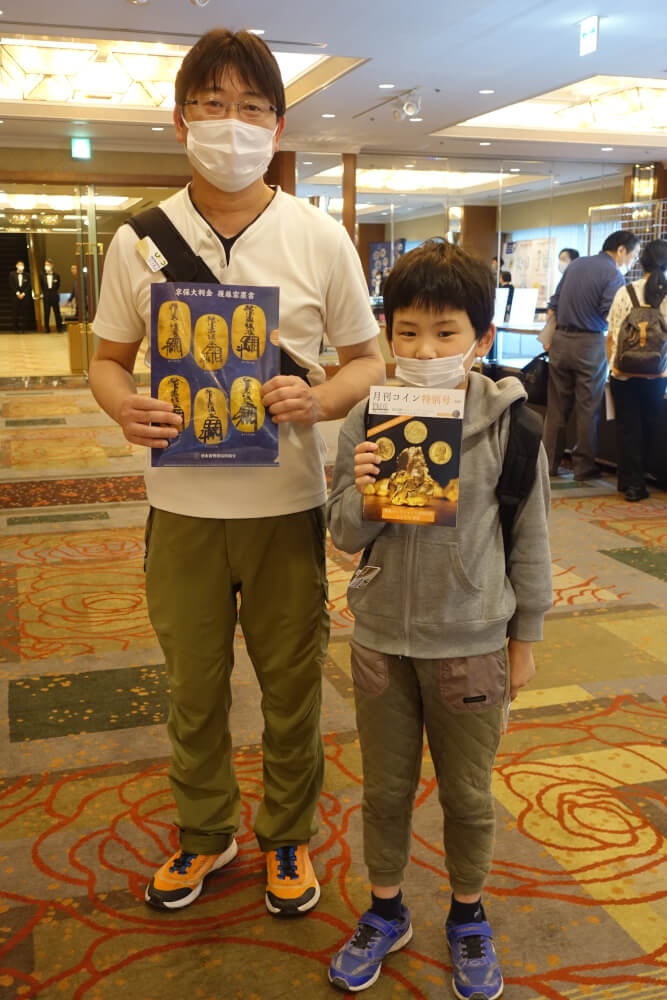 Little Kota allowed us to take his picture with his Dad. He was just one of many young people that are highly interested in numismatics. Photo: UK.
