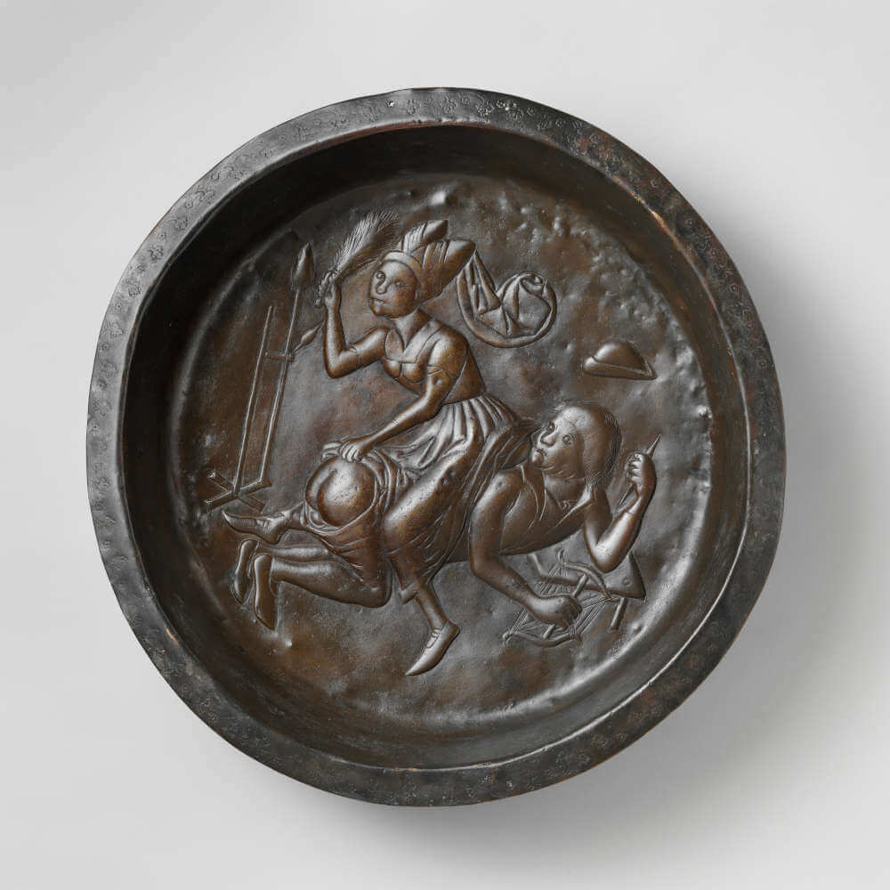 Plate with Wife Beating Husband. Netherlandish. Plate. ca. 1480. Dinant or Malines. Copper alloy, wrought. Overall: 3 7/8 x 20 1/4 in. (9.8 x 51.5 cm) Gift of Irwin Untermyer, 1964 64.101.1499.